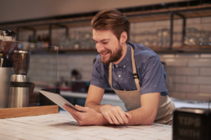 coffee shop employee looking at tablet and tracking local vanity numbers