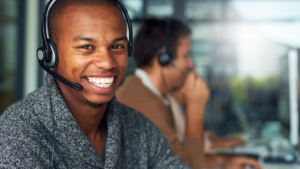 male customer service agent smiling and wearing a headset